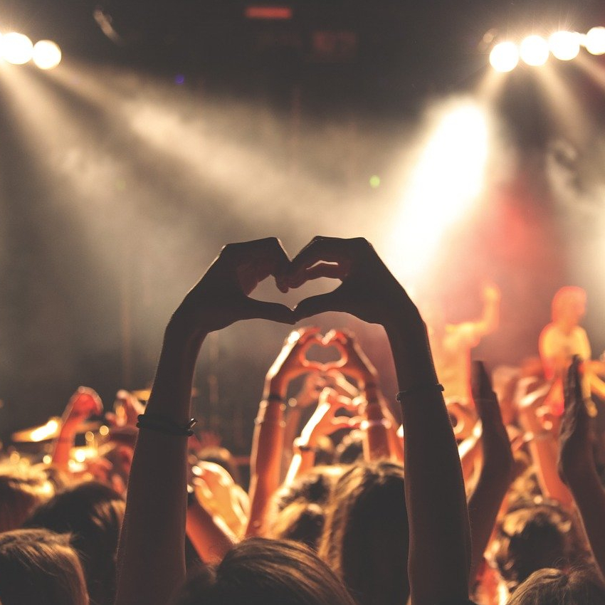image of a girl's hand showing the love sign in appreciation of what she's watching