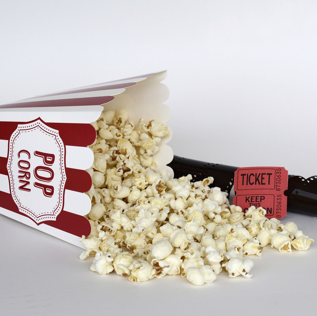 image of popcorn a theatre ticket and a film roll for movies reviews by thatbhaumikgirl