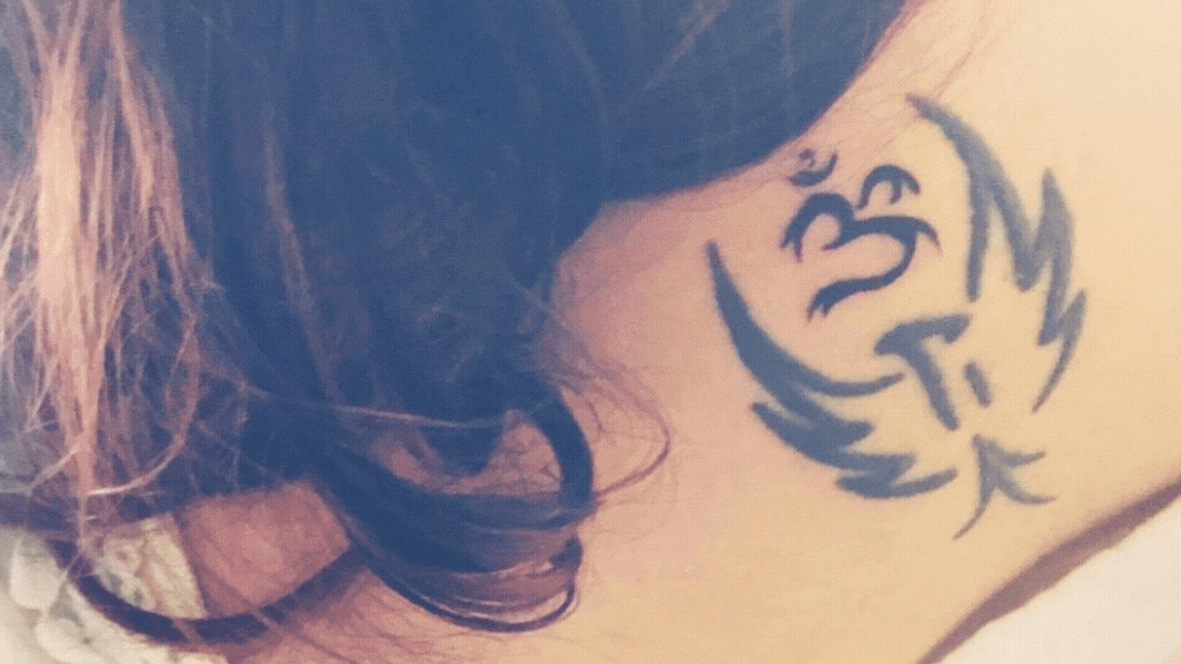 thatbhaumikgirl's tattoo of a phoenix and the spiritual symbol of Om calling out to divine energy for strength while reinventing oneself, at the name of her neck